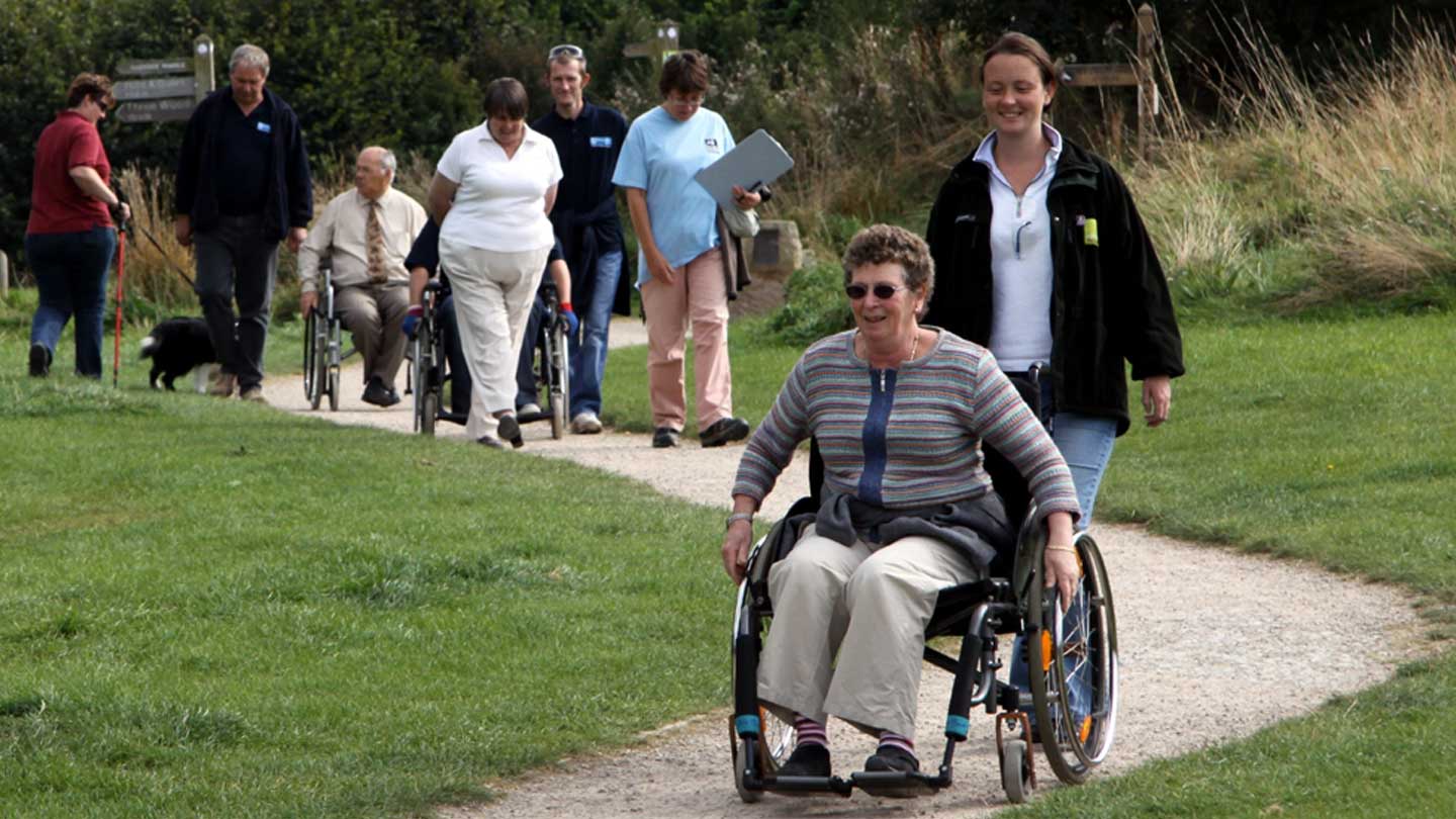 A group of people including wheelchair users on a countryside path in Shropshire