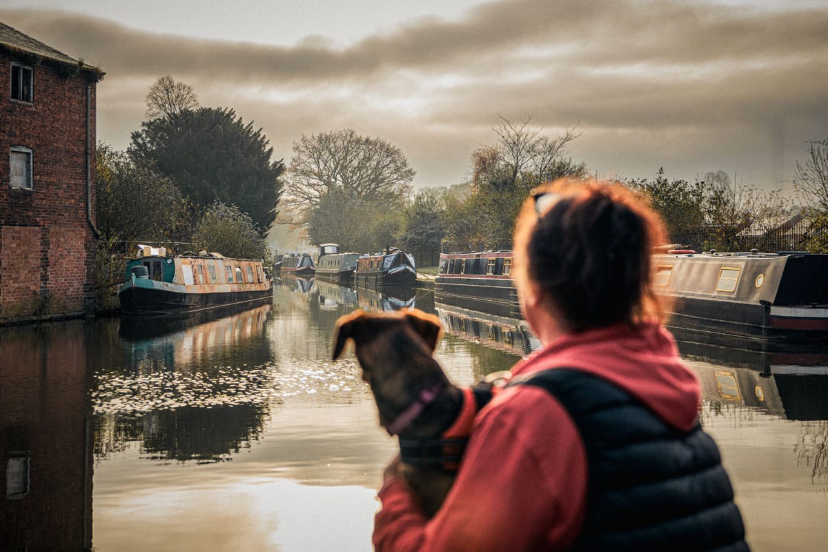 Lady and dog overlooking Ellesmere canal yard