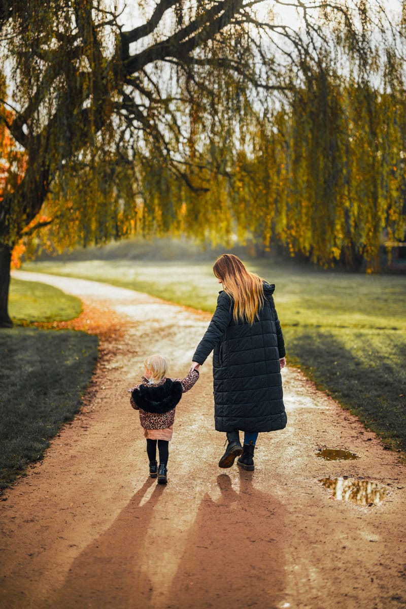 Mum and daughter walking through the park at the Mere