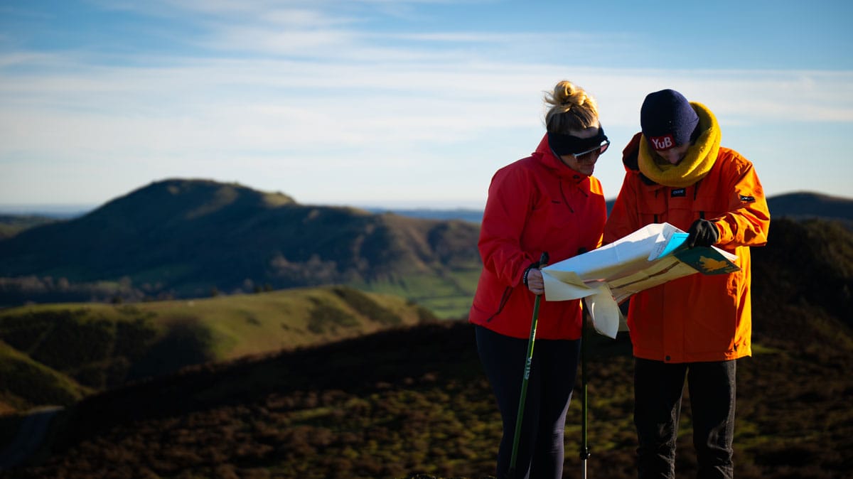 A couple of walkers in the countryside check a map