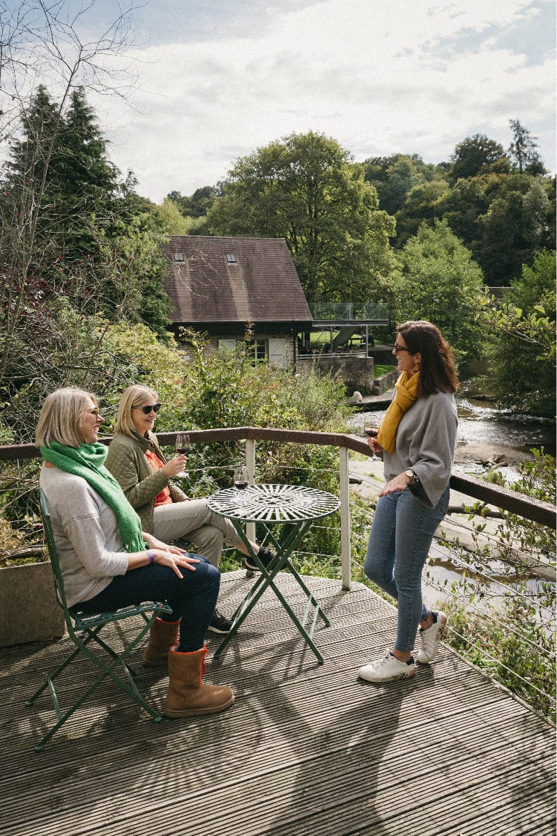 Group of women chatting and drinking win looking at the river in Ludlow