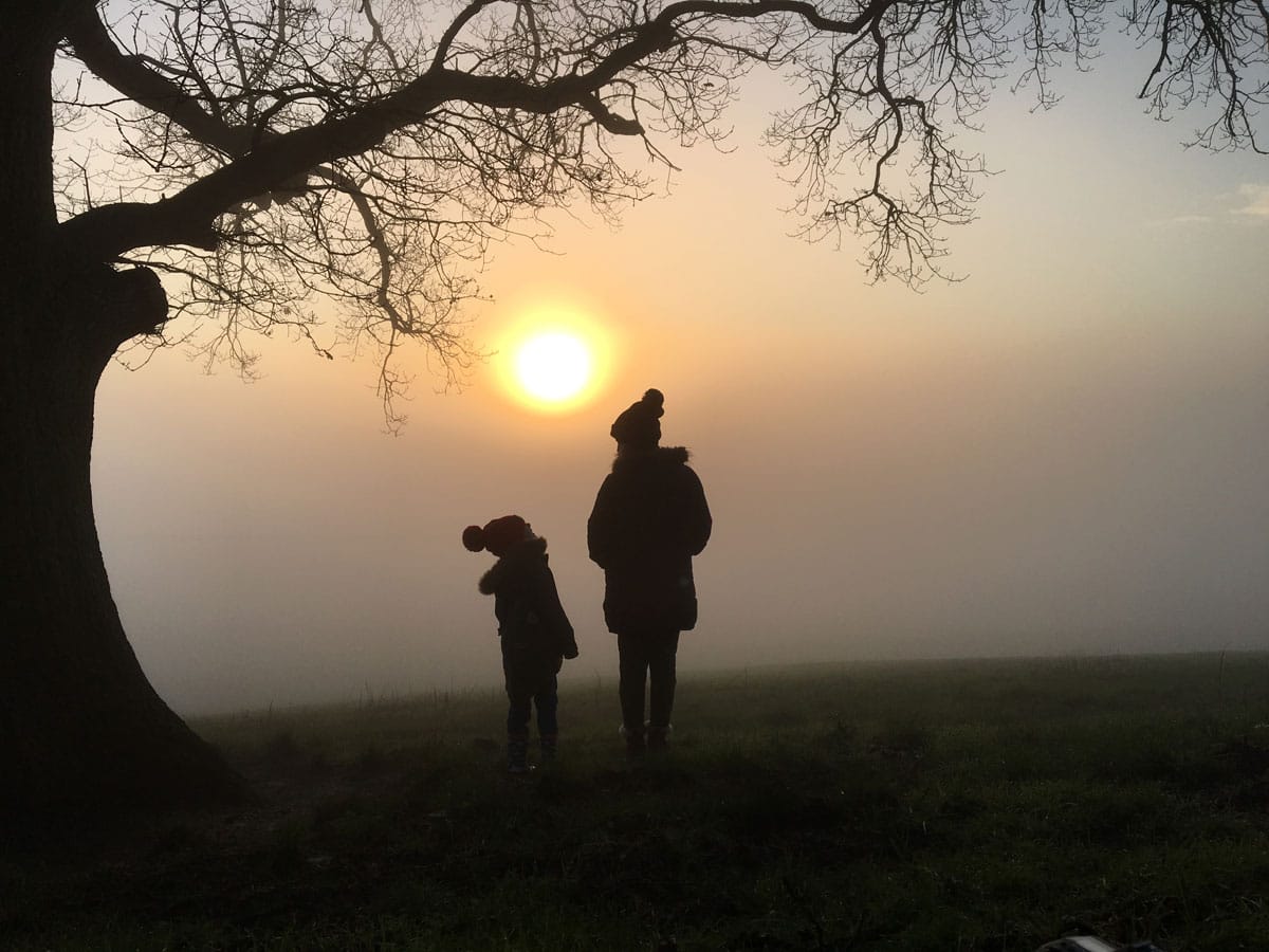 Mum and son wearing bobble hats looking at the moon