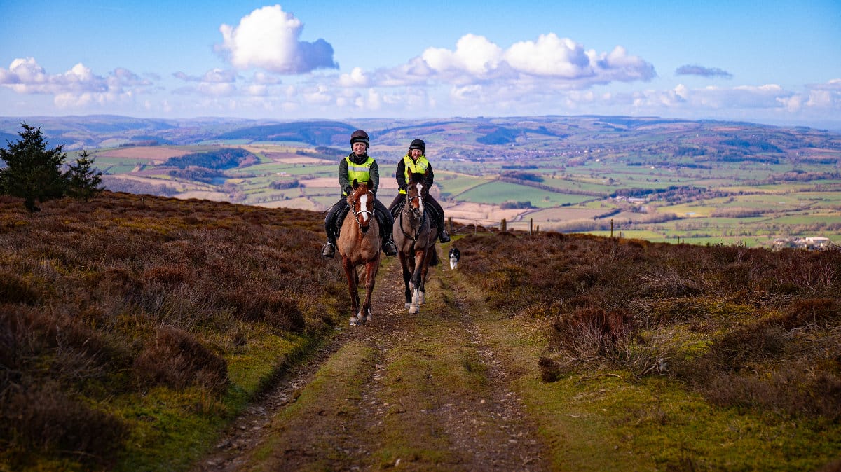 Two riders on horses in the Shropshire countryside