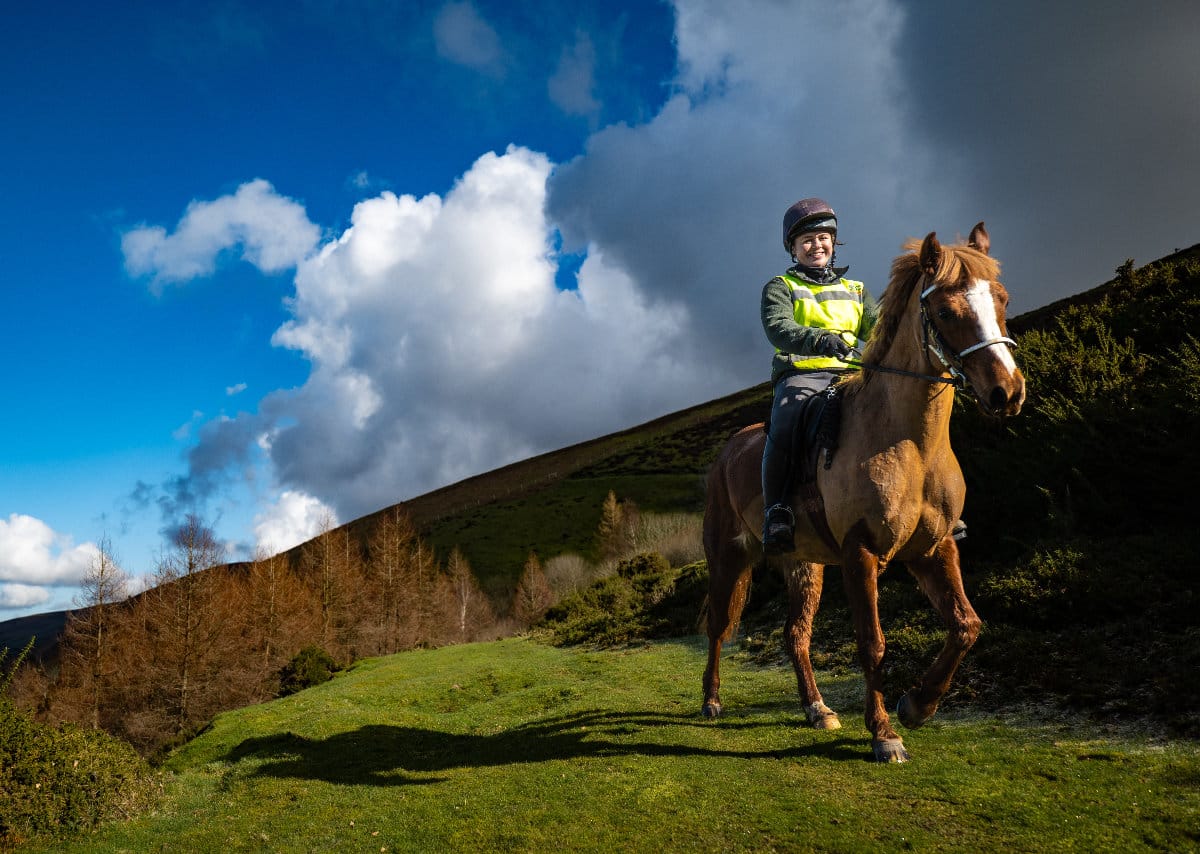 A horse rider in the countryside on a bright day