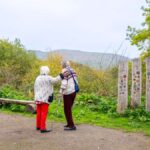 Two elderly people looking towards Earl's Hill from Poles Coppice Picnic Area.