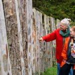 Two people looking at an artistic interpretation at Poles Coppice.