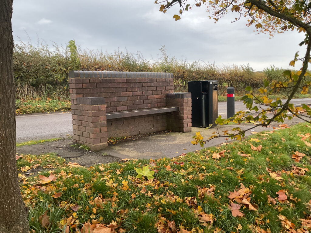 Photo of a brick bench with armrests at Leighton.