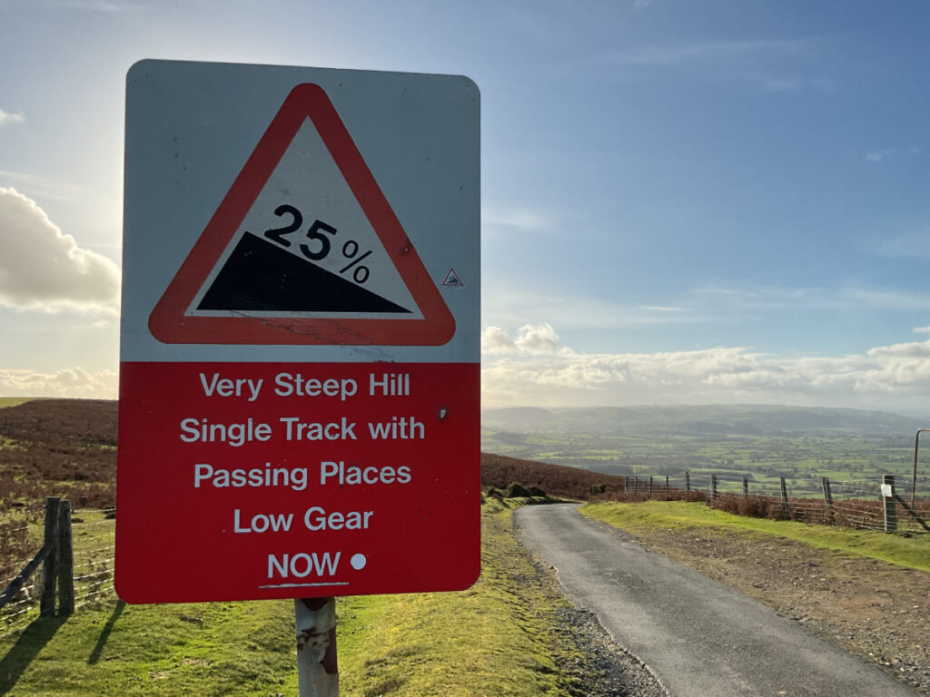 Photo showing a road sign at Asterton Gliding Club that reads 25 percent decline and warns drivers of the very steep hill ahead.