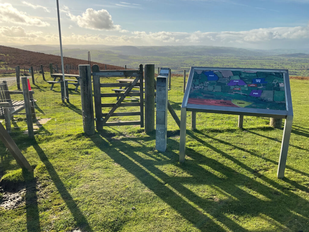 Photo showing a small gate and an interpretation panel close to the viewpoint at the midland gliding club.